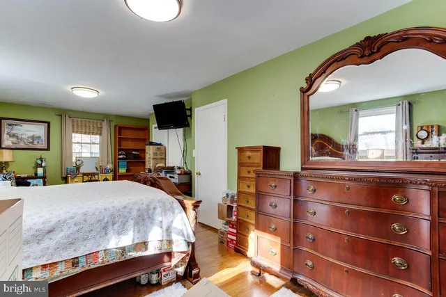 a bedroom with a bed and a mirror on the dresser