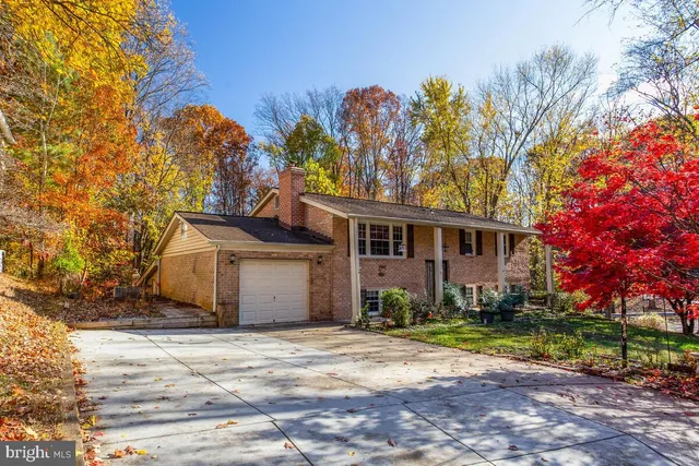 a front view of a house with a yard and tree s