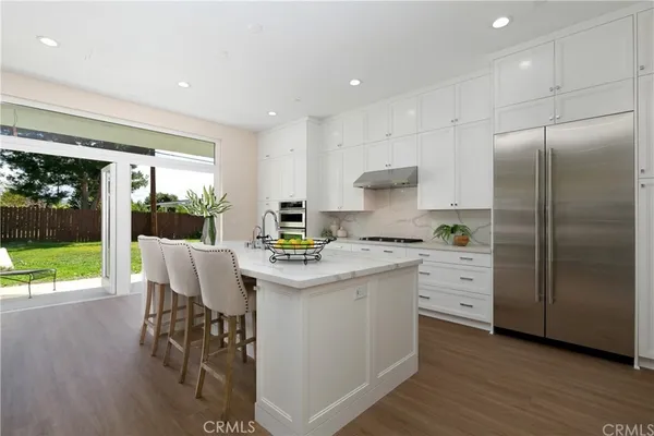 a kitchen with a table chairs refrigerator and microwave