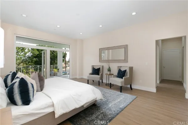 a bedroom with a bed a couch and large window