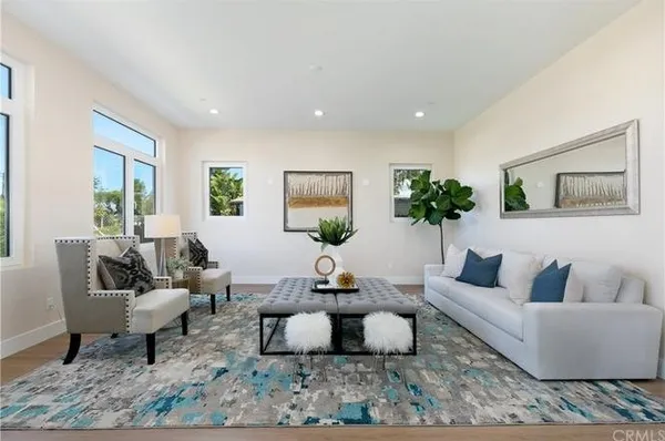 a living room with furniture a rug a lamp and a window