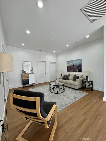 a living room with furniture and a wooden floor