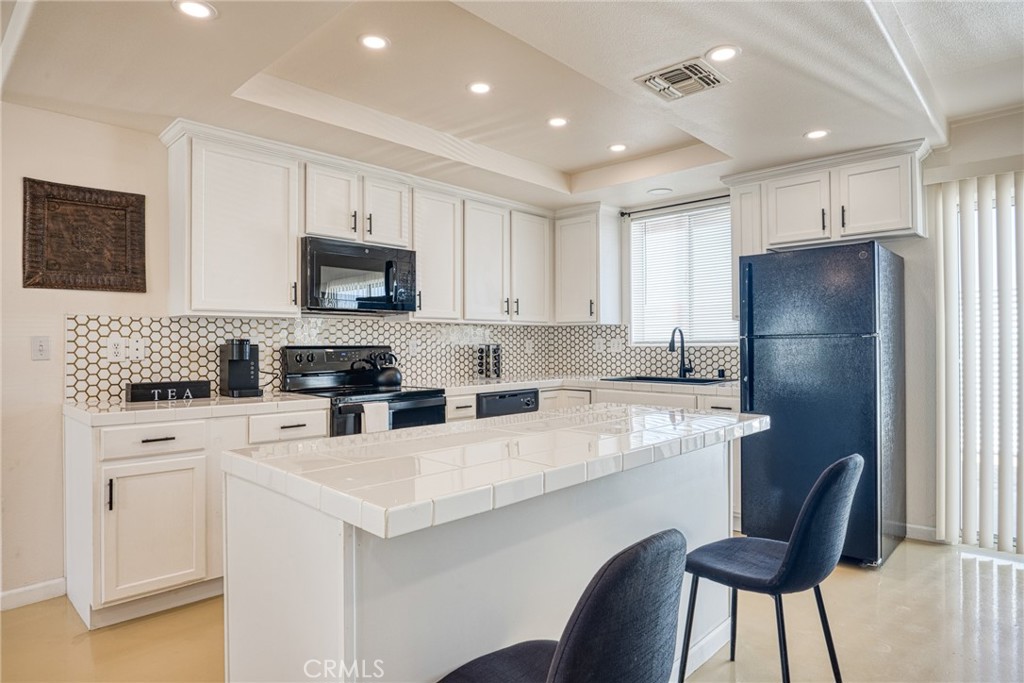 a kitchen with a white cabinets and chairs