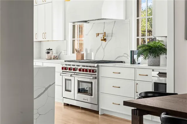 a kitchen with stainless steel appliances white cabinets and a window