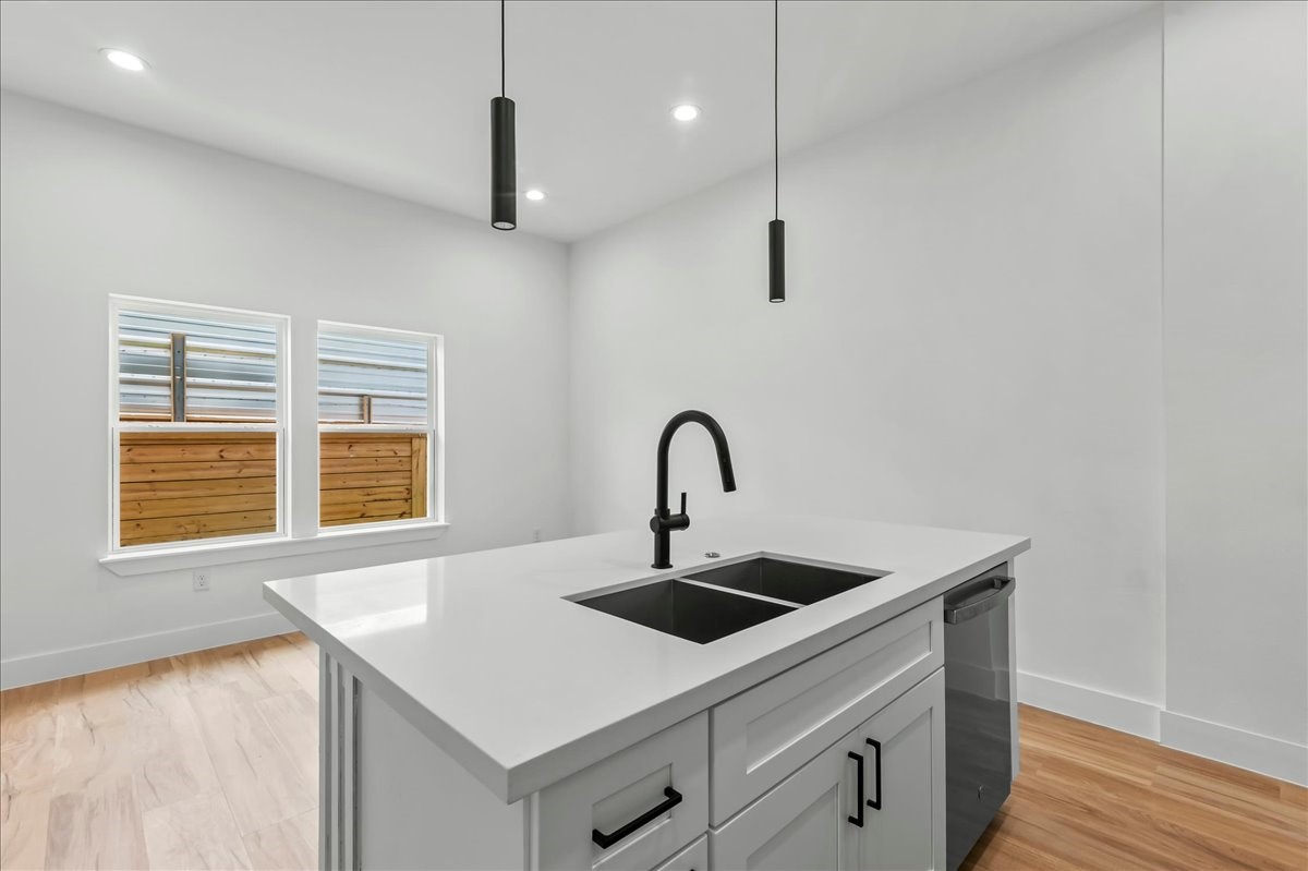 8323 Observatory Street, Unit A/B Houston, TX 77088 - Photo 23 of 38 Unit B - The spacious kitchen island serves as the centerpiece of the home, offering a seamless view of the dining area and large windows that fill the space with natural light.