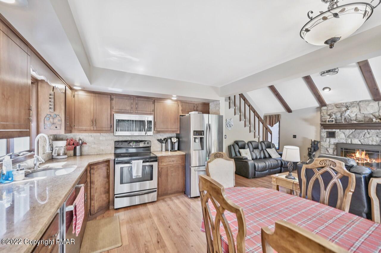 134 Moseywood Road Lake Harmony, PA 18624 - Photo 11 of 70 a kitchen with stainless steel appliances a stove top oven a sink a dining table and chairs