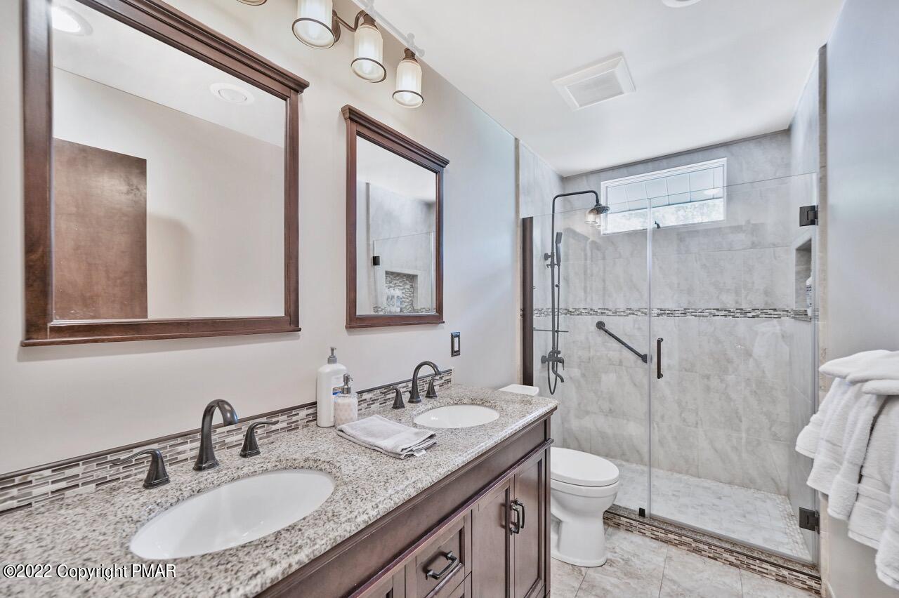 134 Moseywood Road Lake Harmony, PA 18624 - Photo 18 of 70 a bathroom with a granite countertop sink toilet mirror and shower