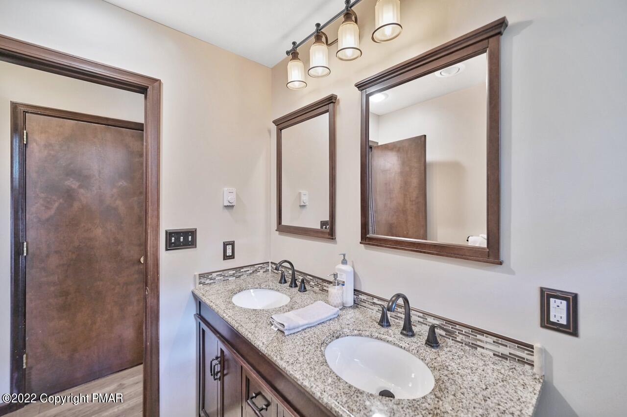 134 Moseywood Road Lake Harmony, PA 18624 - Photo 19 of 70 a bathroom with a granite countertop sink a mirror and a shower