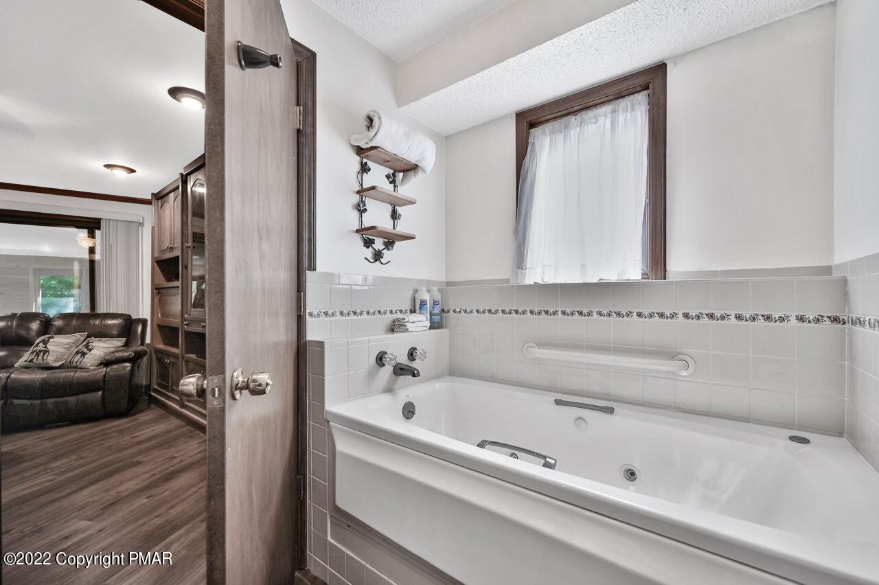 134 Moseywood Road Lake Harmony, PA 18624 - Photo 36 of 70 a bathroom with a bathtub and a hallway