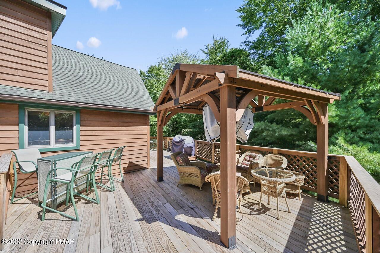 134 Moseywood Road Lake Harmony, PA 18624 - Photo 52 of 70 a view of a patio with table and chairs potted plants with wooden floor and fence