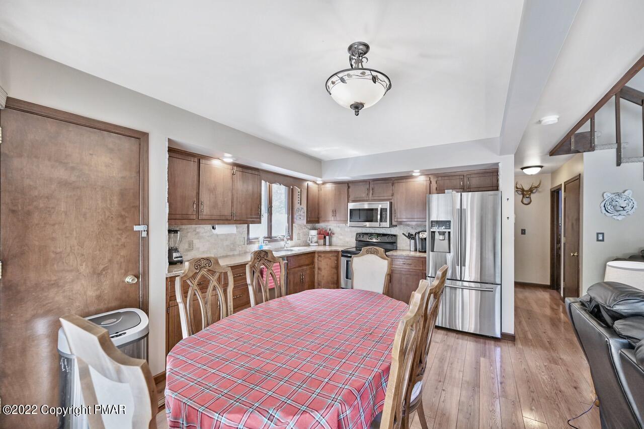 134 Moseywood Road Lake Harmony, PA 18624 - Photo 10 of 70 a kitchen with stainless steel appliances kitchen island granite countertop a dining table chairs and a refrigerator