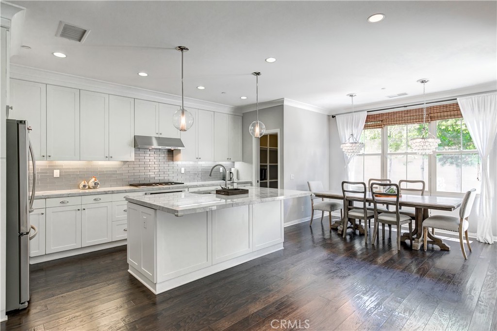 72 Cherry Tree Irvine, CA 92620 - Photo 6 of 15 a kitchen with appliances a sink a stove a dining table and chairs