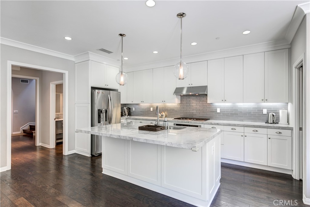 72 Cherry Tree Irvine, CA 92620 - Photo 7 of 15 a kitchen with stainless steel appliances granite countertop a stove a sink a refrigerator and white cabinets with wooden floor
