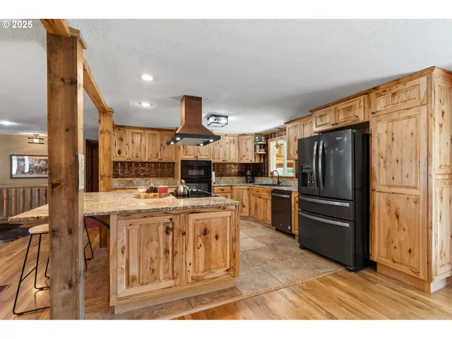 a kitchen with kitchen island a refrigerator stove and oven