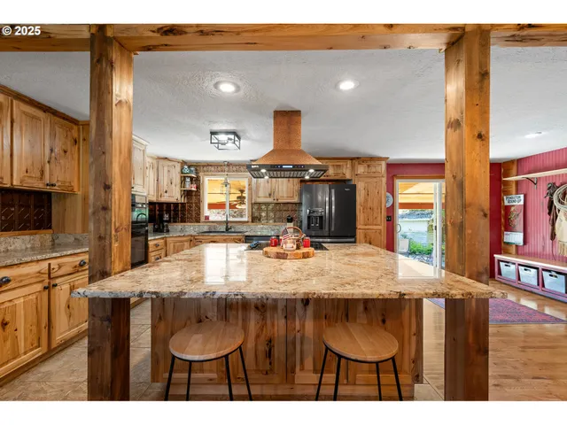 a kitchen with kitchen island granite countertop a table and chairs in it