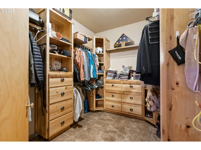 a view of walk in closet with clothes and shoes