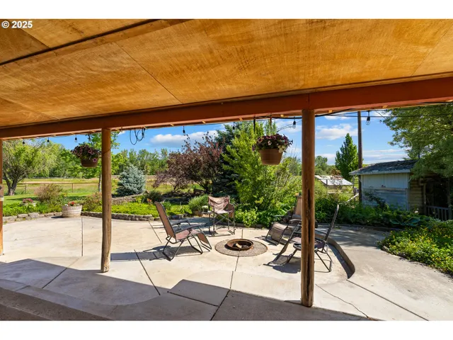 a view of a patio with a table and chairs under an umbrella