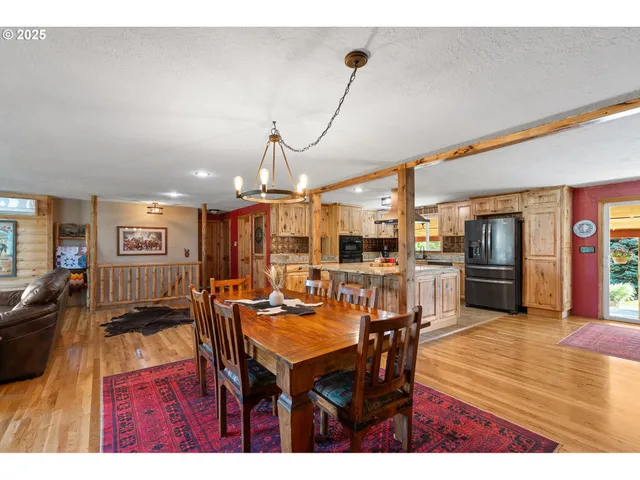 a view of a dining room and livingroom with furniture wooden floor a chandelier