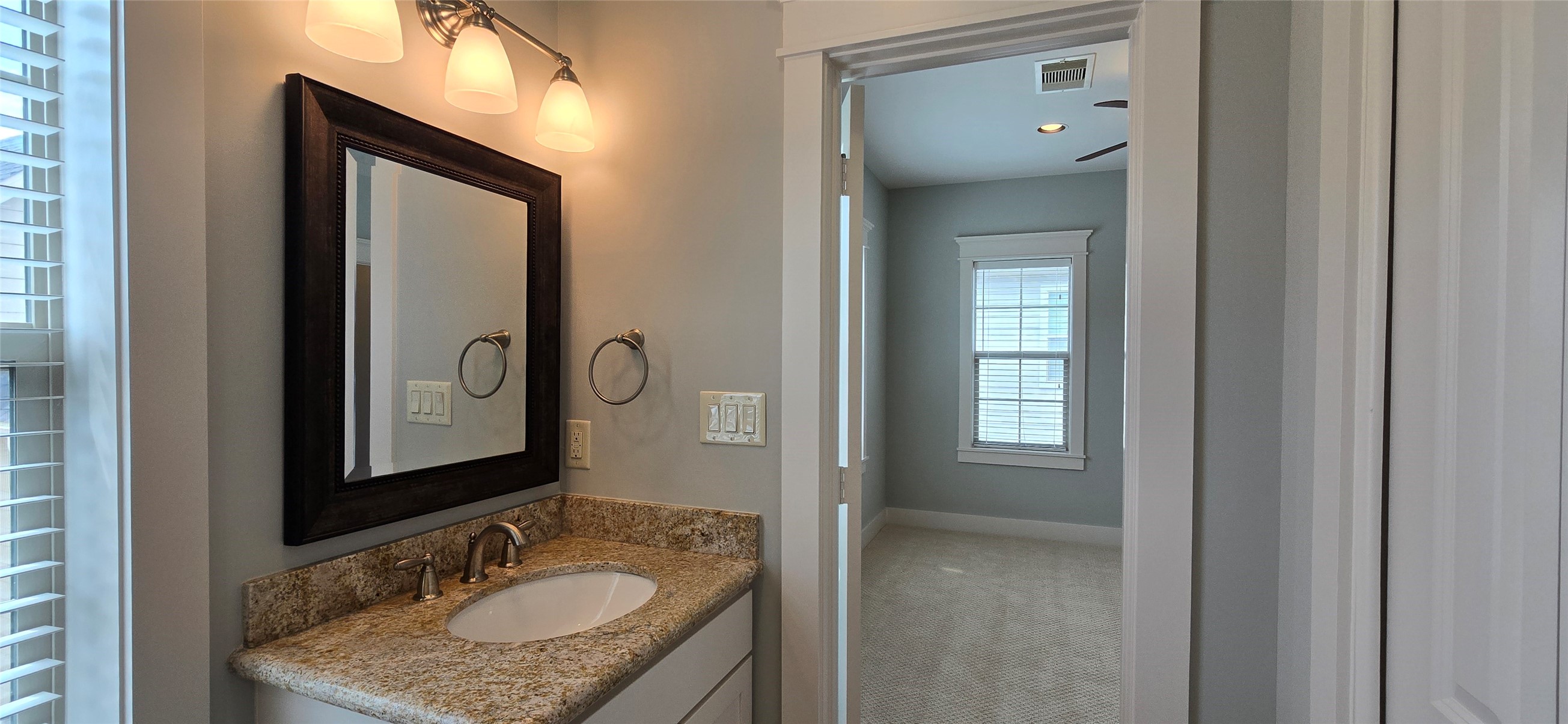 1117 Bonner Street Houston, TX 77007 - Photo 28 of 44 Decorative lighting and a framed mirror sit above the granite topped vanity.