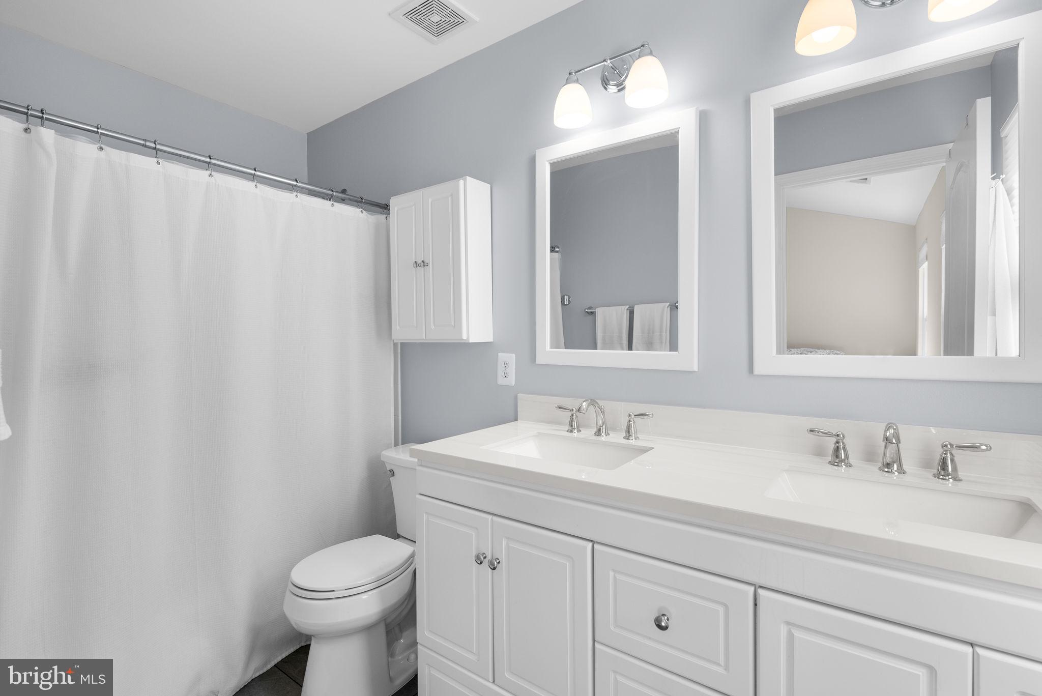 215 Poplar Spring Road Rockville, MD 20850 - Photo 17 of 30 a bathroom with a granite countertop sink a toilet and a mirror
