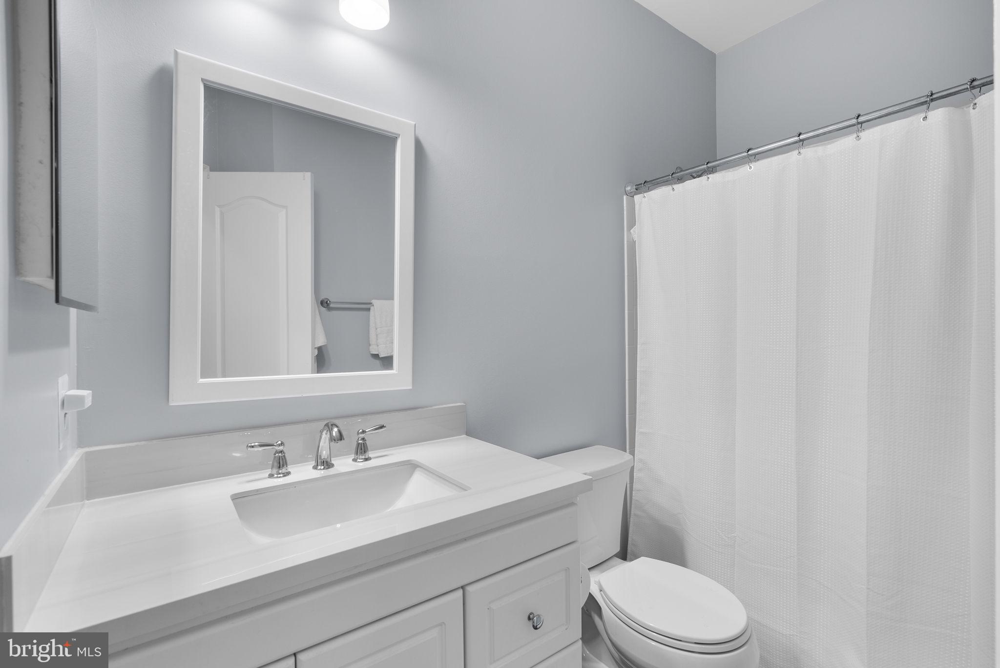 215 Poplar Spring Road Rockville, MD 20850 - Photo 22 of 30 a bathroom with a sink vanity mirror and toilet