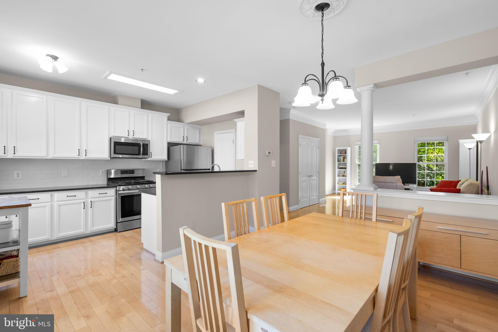 215 Poplar Spring Road Rockville, MD 20850 - Photo 7 of 30 a kitchen with stainless steel appliances granite countertop a sink dishwasher a stove a microwave oven a refrigerator with island and chairs