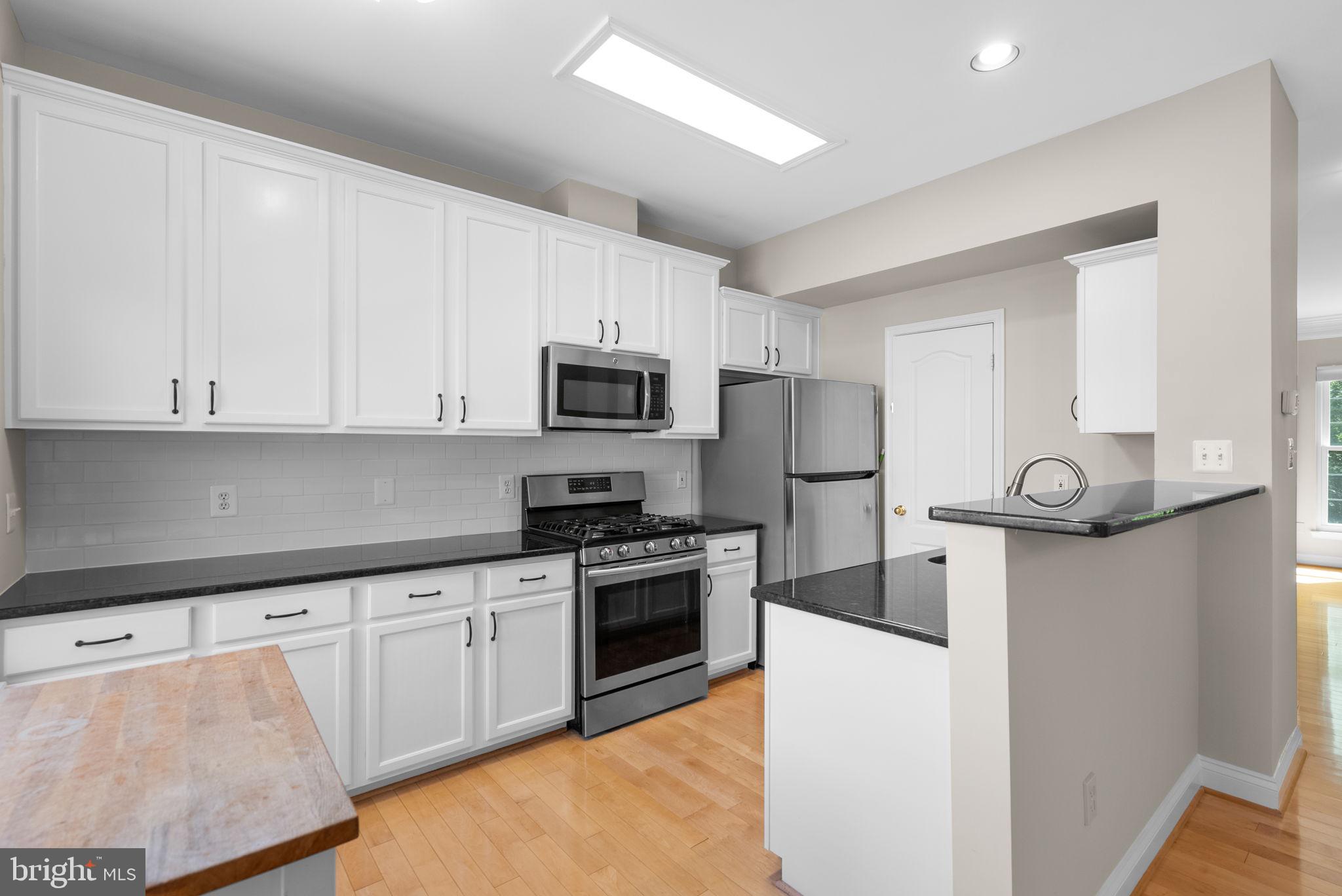 215 Poplar Spring Road Rockville, MD 20850 - Photo 8 of 30 a kitchen with white cabinets stainless steel appliances and sink