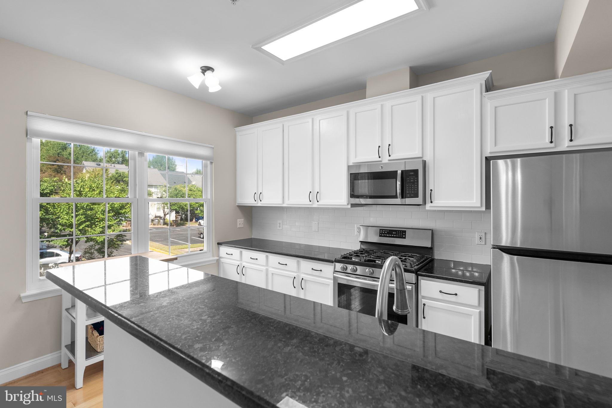 215 Poplar Spring Road Rockville, MD 20850 - Photo 9 of 30 a kitchen with granite countertop white cabinets and stainless steel appliances