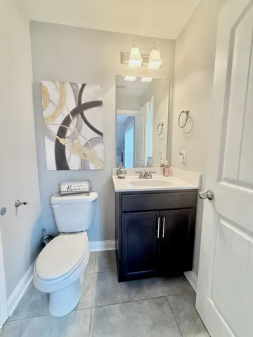 a bathroom with a sink vanity mirror and toilet