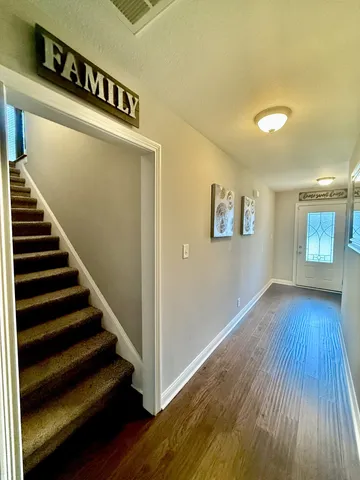a view of entryway and hall with wooden floor