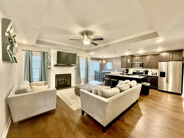 a living room with furniture kitchen view and a fireplace