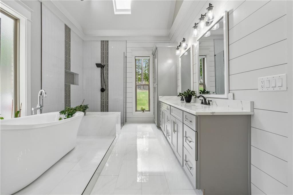 852 Tom Miller Road Bethlehem, GA 30620 - Photo 45 of 68 a bathroom with a double vanity sink a large mirror and a bathtub