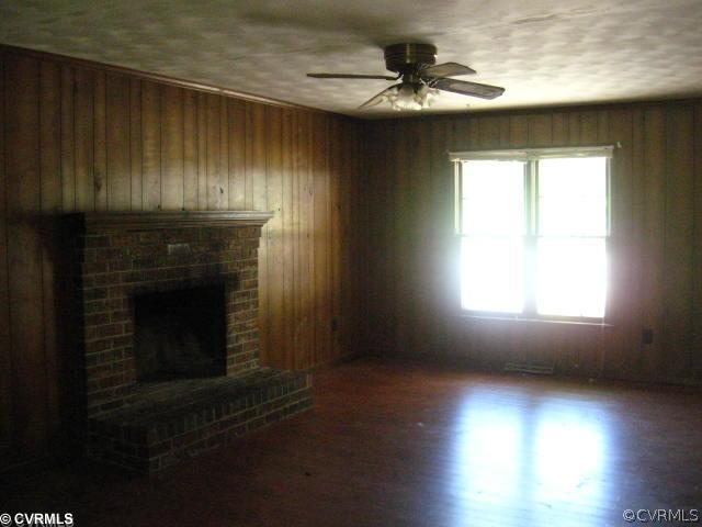 11512 Genito Road Midlothian, VA 23112 - Photo 3 of 3 an empty room with wooden floor fireplace and windows