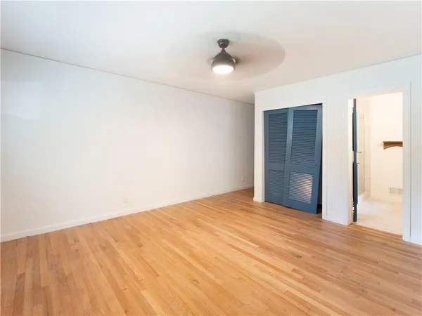 a view of empty room with wooden floor