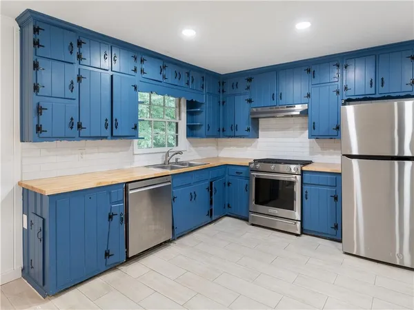 a kitchen with wooden cabinets stainless steel appliances and a sink