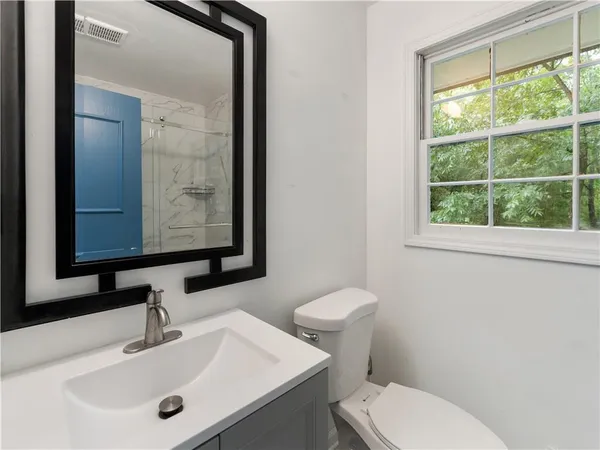 a bathroom with a toilet sink and mirror