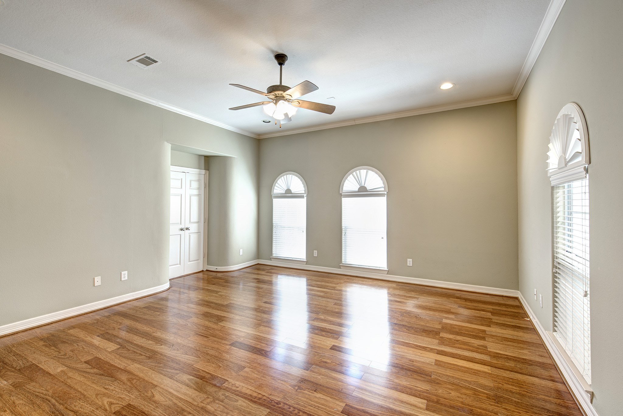 4003 Feagan Street, Unit 2 Houston, TX 77007 - Photo 16 of 25 Primary bedroom with hardwood floors and plantation shutters in the transom and wood blinds in the windows.