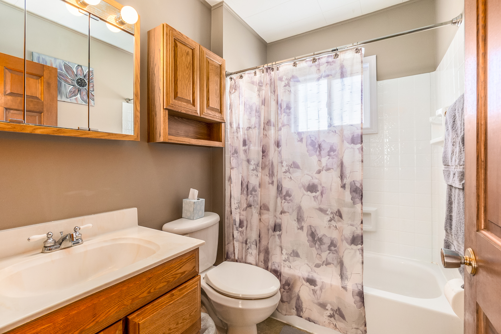 28W418 Batavia Road Warrenville, IL 60555 - Photo 9 of 24 a bathroom with a sink a toilet and shower curtain