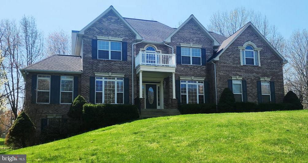 90 Oxford Way Huntingtown, MD 20639 - Photo 2 of 32 a view of a brick house with many windows and a yard