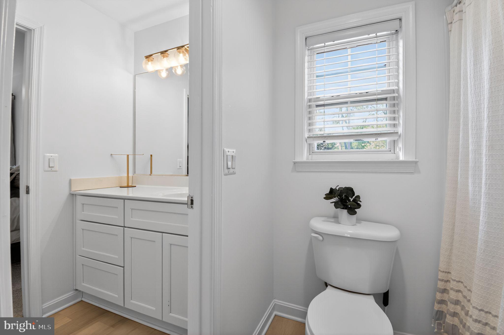 90 Oxford Way Huntingtown, MD 20639 - Photo 26 of 32 a bathroom with a toilet a sink and mirror