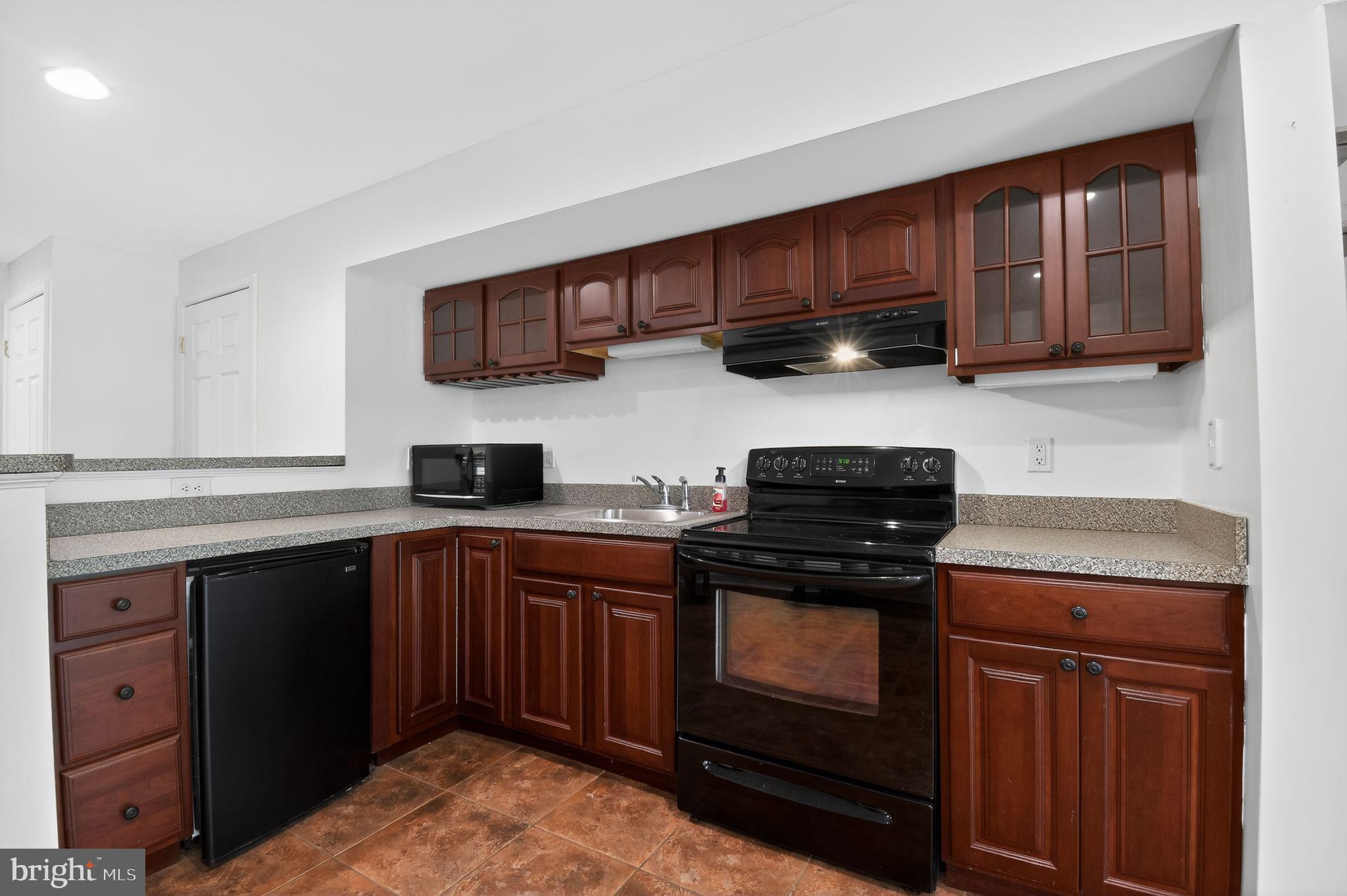 90 Oxford Way Huntingtown, MD 20639 - Photo 31 of 32 a kitchen with stainless steel appliances granite countertop wooden cabinets stove top oven and sink