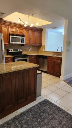 a kitchen with stainless steel appliances granite countertop a stove a sink and a microwave
