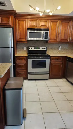 a kitchen with granite countertop a stove and a microwave