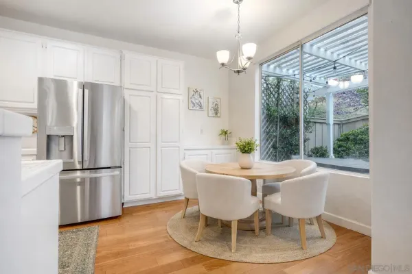 a dining room with furniture a chandelier and wooden floor