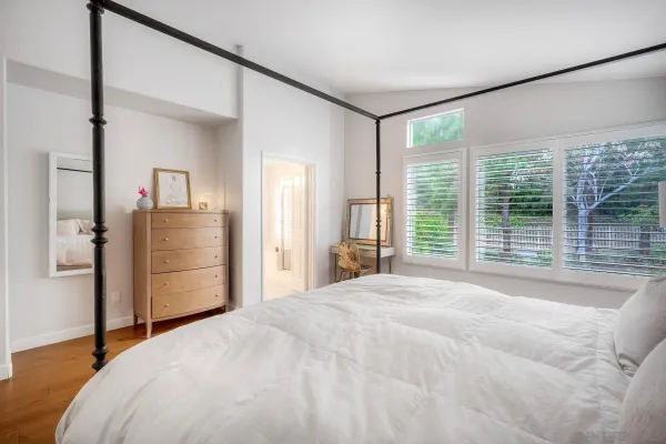a bedroom with a bed and a large mirror