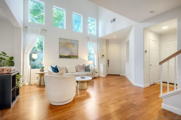 a living room with furniture a large window and wooden floor