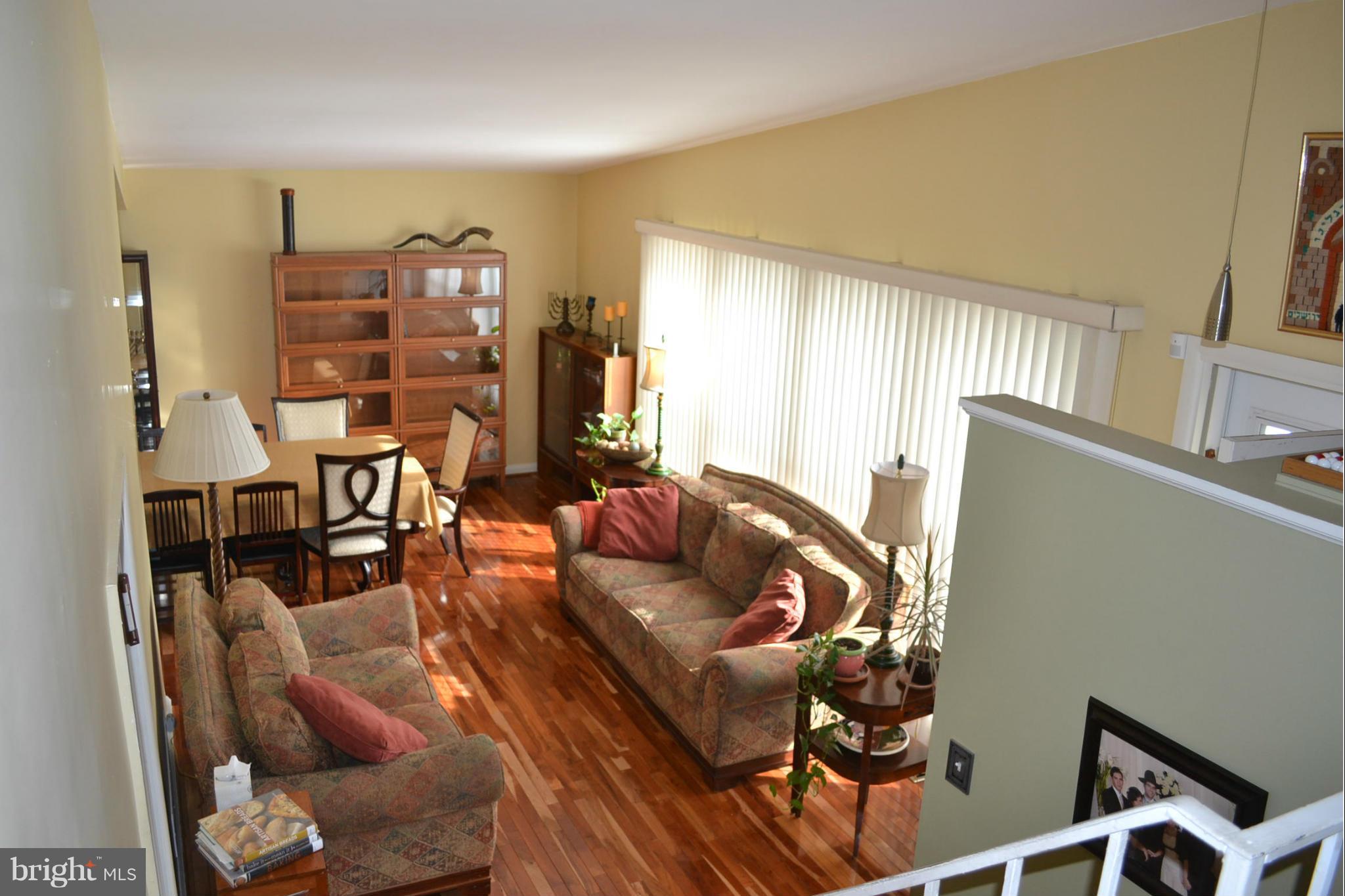3208 Bonnie Road Baltimore, MD 21208 - Photo 14 of 21 a living room with furniture a lamp and paintings on the wall
