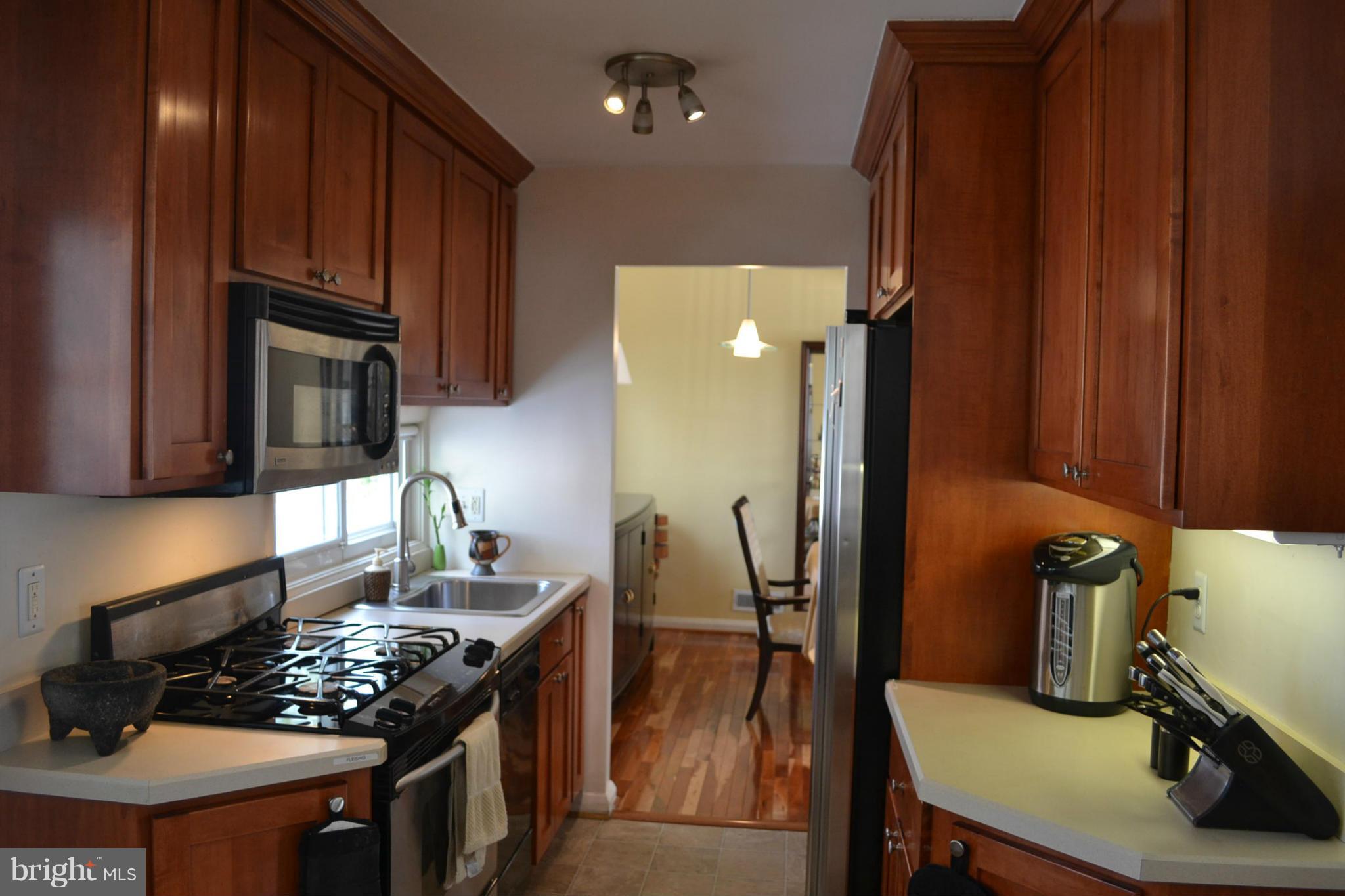 3208 Bonnie Road Baltimore, MD 21208 - Photo 5 of 21 a kitchen with stainless steel appliances a stove a sink dishwasher and cabinets with wooden floor
