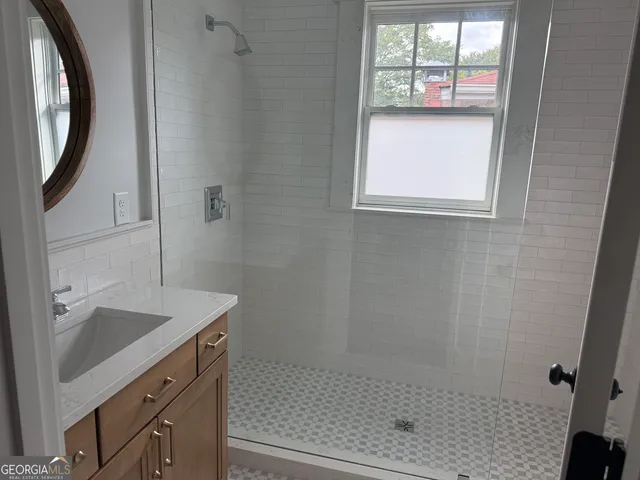 a bathroom with a sink a vanity and a shower