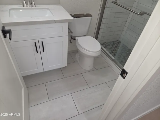 a white toilet sitting next to a white sink